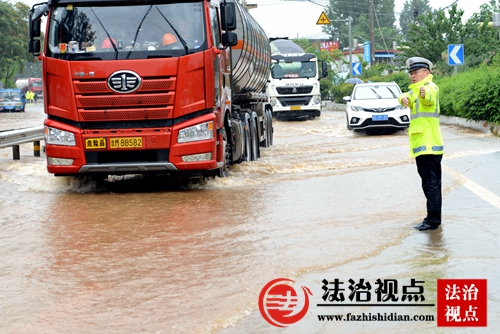 7月14日，山东省枣庄市公安局山亭分局交警大队民警冒雨疏导交通。.jpg