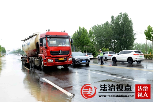 7月14日，山东省枣庄市公安局山亭分局交警大队组织警力冒雨疏导交通，指挥过往车辆安全通行。.jpg