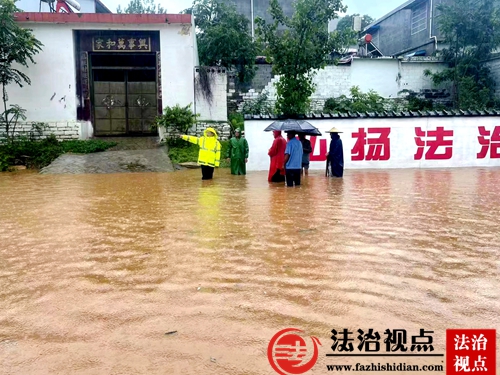 7月14日上午，山东省枣庄市公安局山亭分局交警大队组织警力冒雨疏导交通，站在积水中疏散群众。.jpg