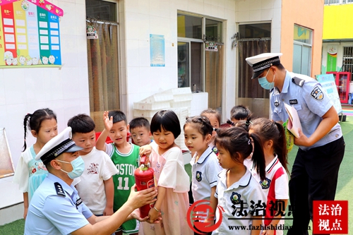 8月2日，山东省枣庄市公安局山亭分局交警大队民辅警深入辖区金苹果幼儿园开展暑期安全宣传活动，手把手教孩子如何正确使用灭火器。.jpg