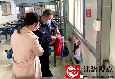 图为民警在校园餐厅检查消防设施.jpg