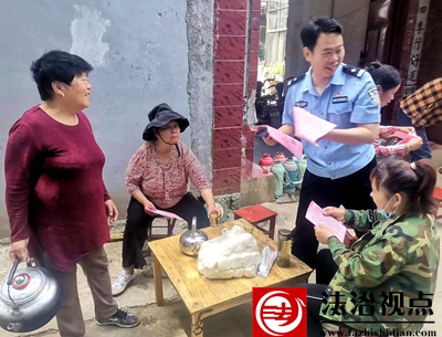 图为民警在农家小院发放资料时和村民宣讲互动.jpg