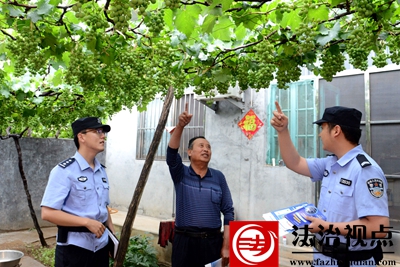 6月18日，枣庄市公安局山亭分局北庄派出所民辅警来到北庄镇洪门村村民王光忠家中走访，在葡萄架下宣传反电诈常识。.jpg